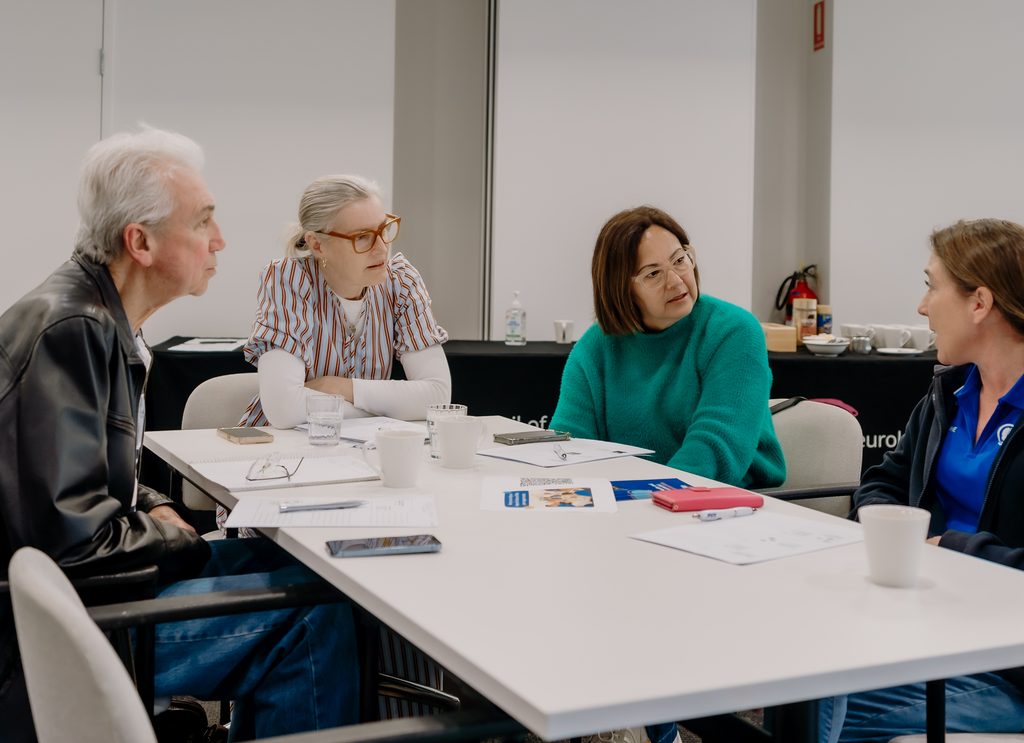 Four workshop participants discussing a case study together around a table.